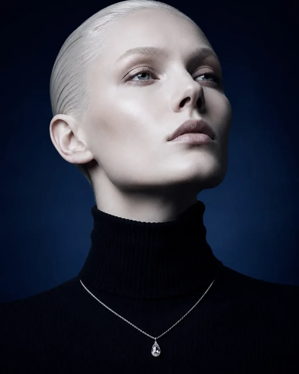 Editorial jewelry shot of a woman's hand pinching a pear-cut