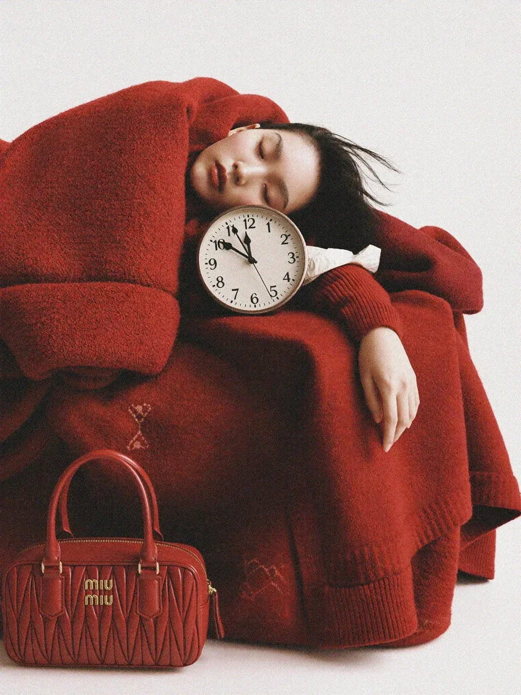 Editorial fashion photograph of a young woman curled up asleep