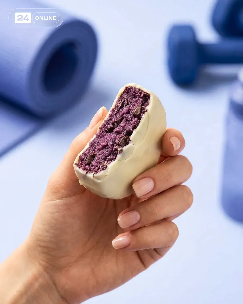 Hand holding a protein blueberry white brownie cut in half
