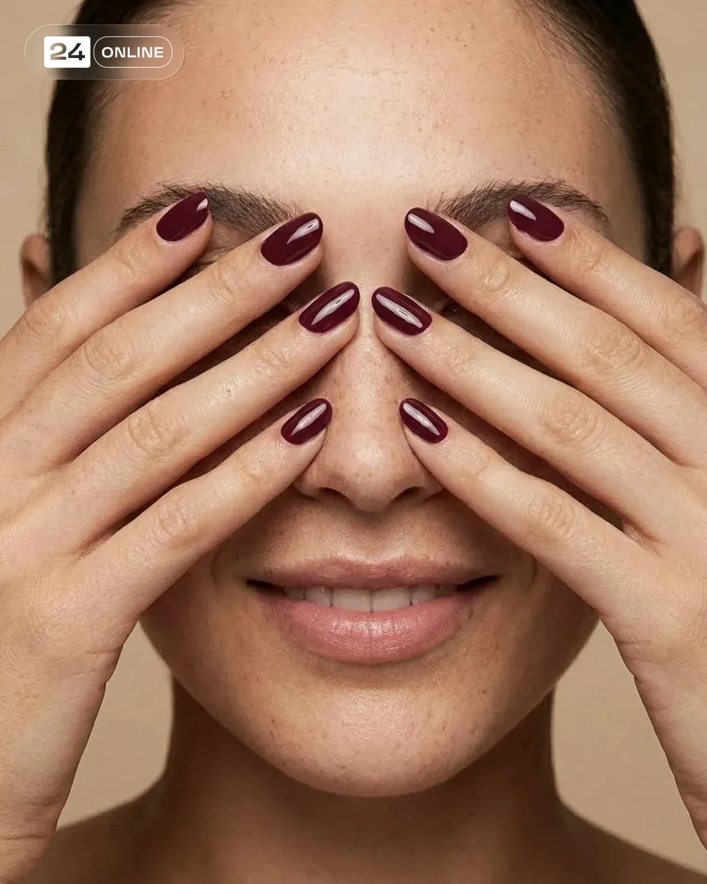 Close-up editorial beauty shot of the woman smiling softly, her