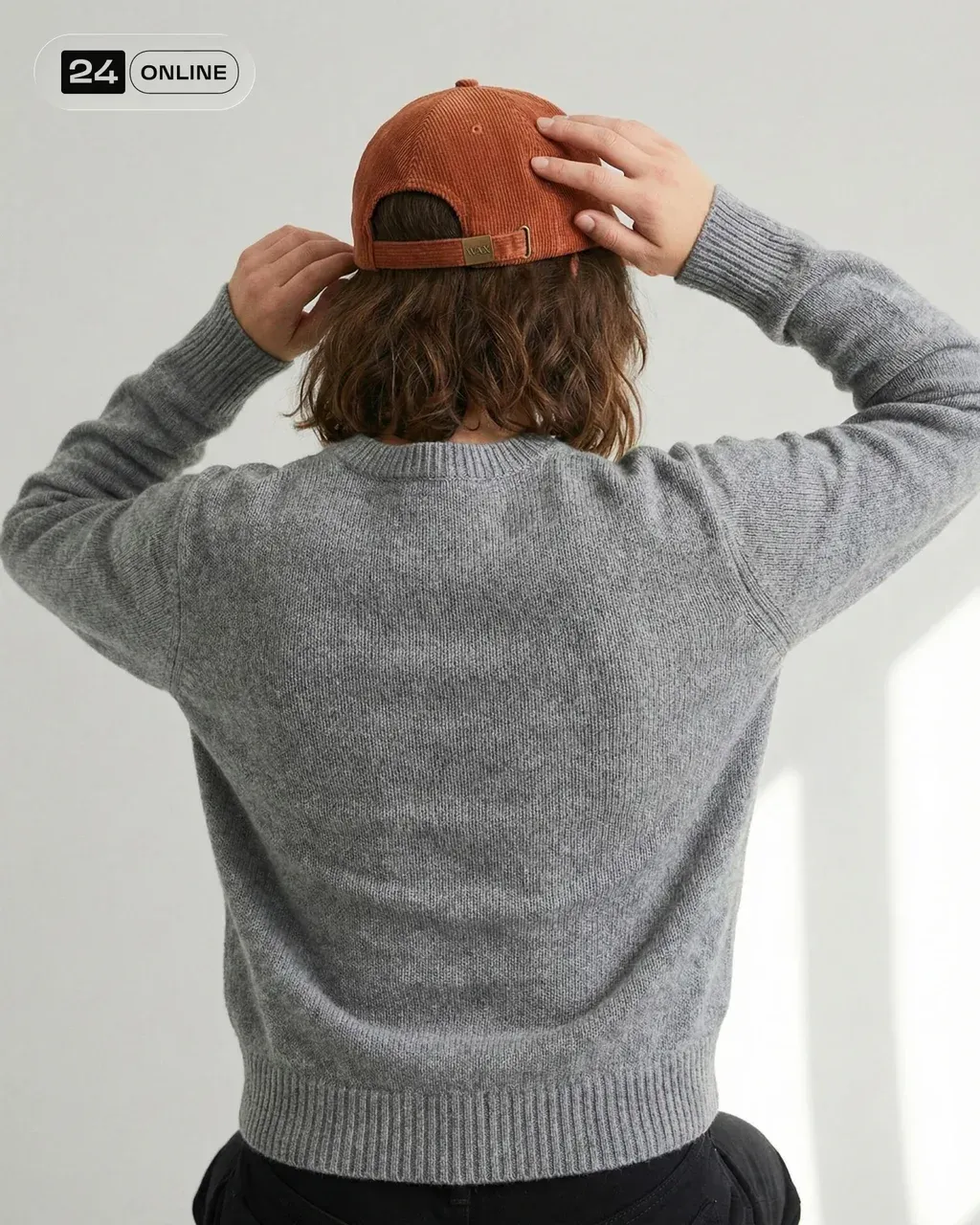 Editorial minimal studio portrait from behind, a young woman wearing