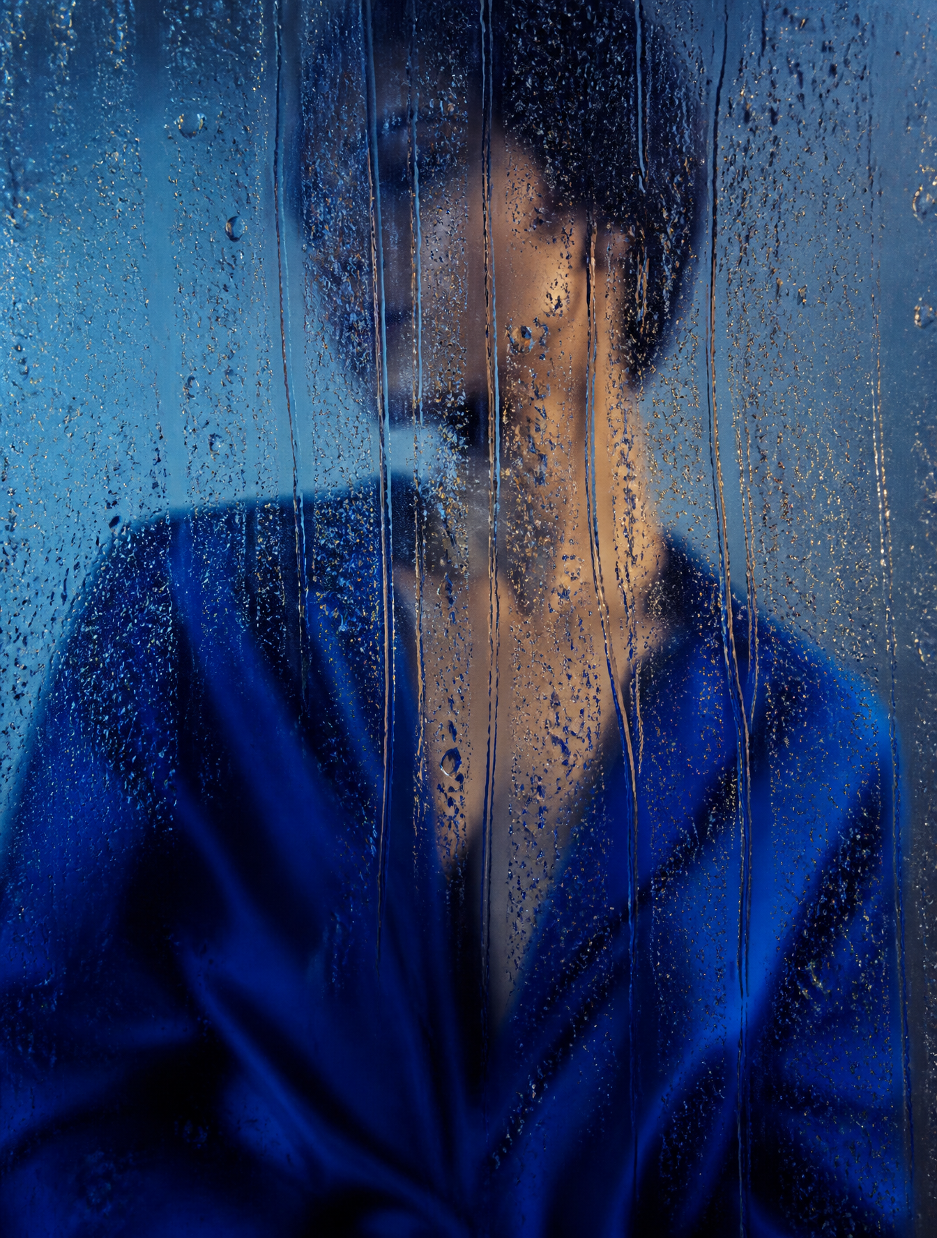 A cinematic editorial fashion photograph of a figure in a saturated cobalt-blue silk garm…