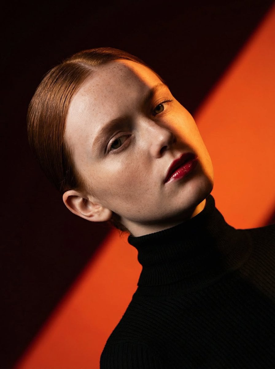 Ultra-high-fashion editorial beauty portrait of a fair-skinned female model with sleek ce…