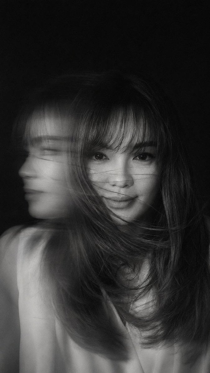 A hyper-realistic, cinematic black-and-white portrait of a woman caught in mid-motion, he…